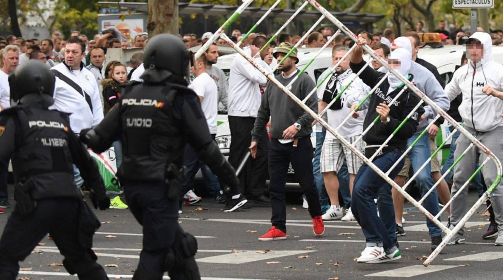 Aficionados del Legia de Varsovia se enfrentan a la Policía Nacional antes del comienzo del partido entre el Madrid y el equipo polaco.