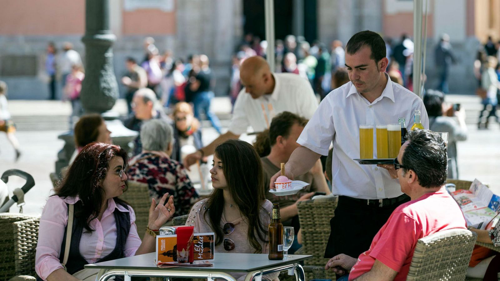 Imagen de archivo de un camarero sirve bebidas en una terraza en Valencia