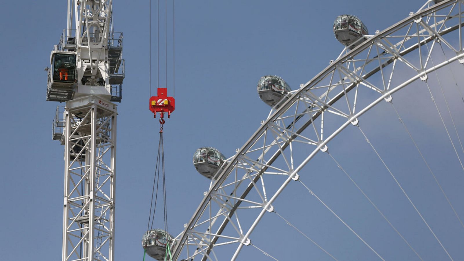 Una grúa al lado de la noria Londoneye en la capital británica