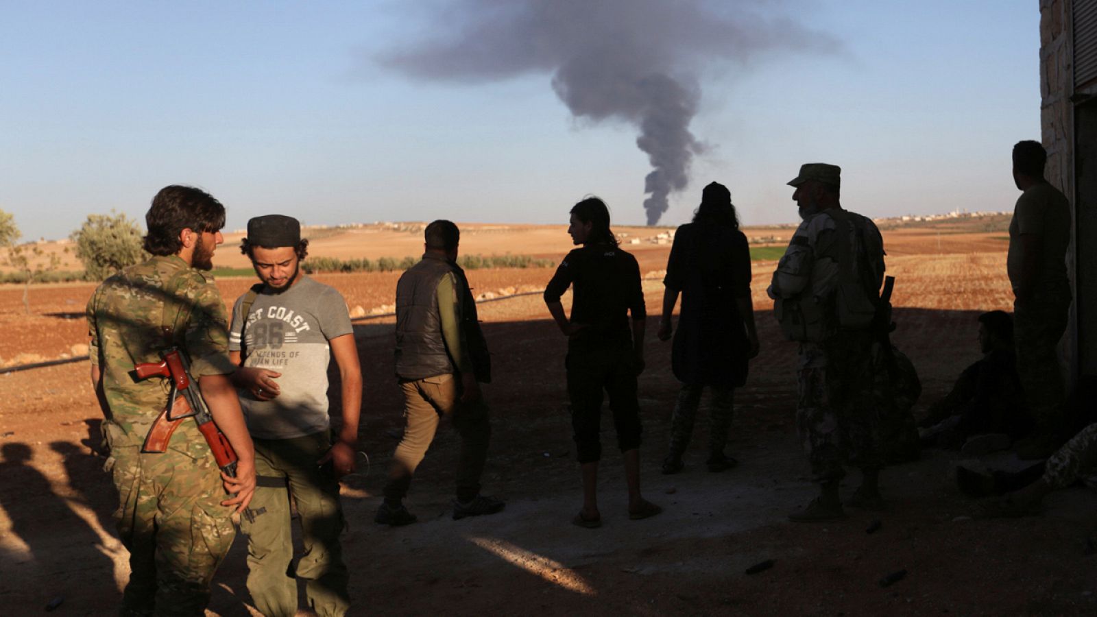 Combatientes rebeldes contemplan una columna de humo en la zona de Al-Bab en Alepo