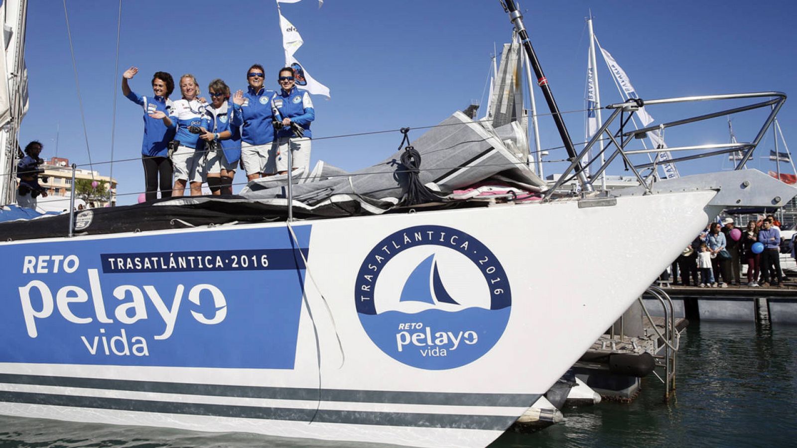 Las cinco mujeres que sobrevivieron al cáncer de mama saludan antes de zarpar del puerto de Valencia.