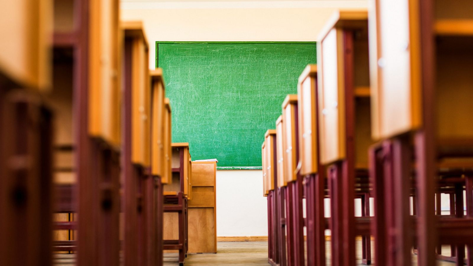 Aula con pupitres vacíos y una pizarra al fondo