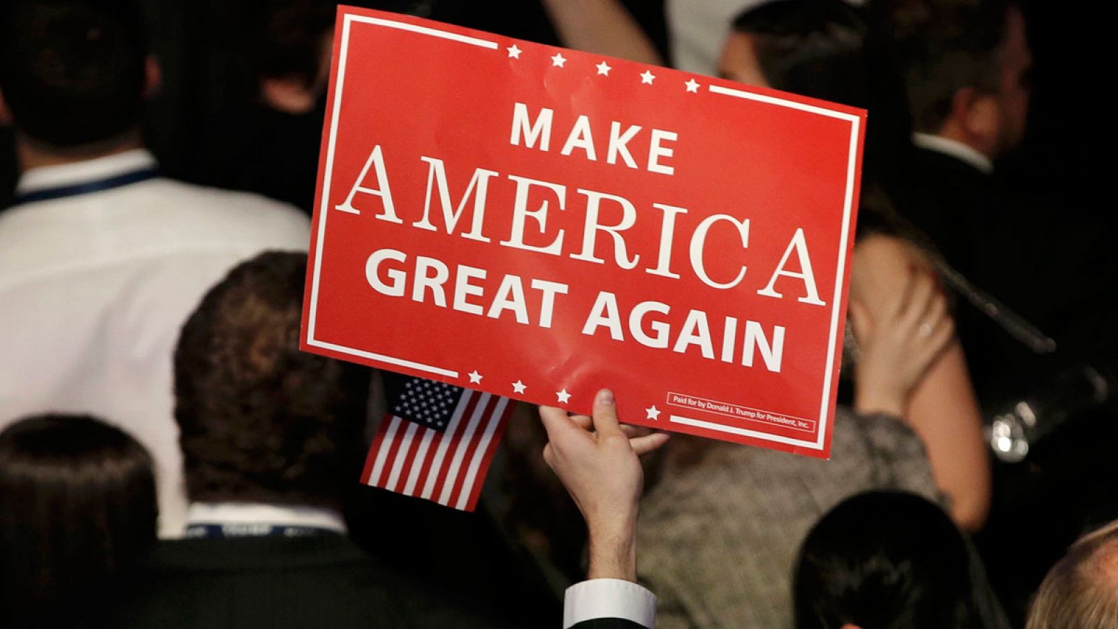 Un seguidor republicano con un lema de campaña de Trump: "Recuperar la grandeza de EE.UU."
