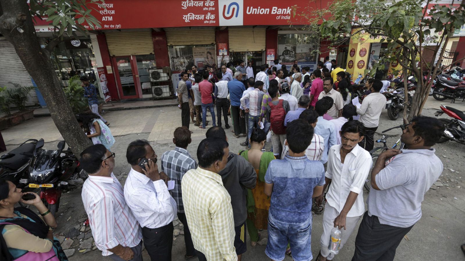 Una multitud de ciudadanos indios hace cola ante una entidad bancaria para cambiar sus billetes