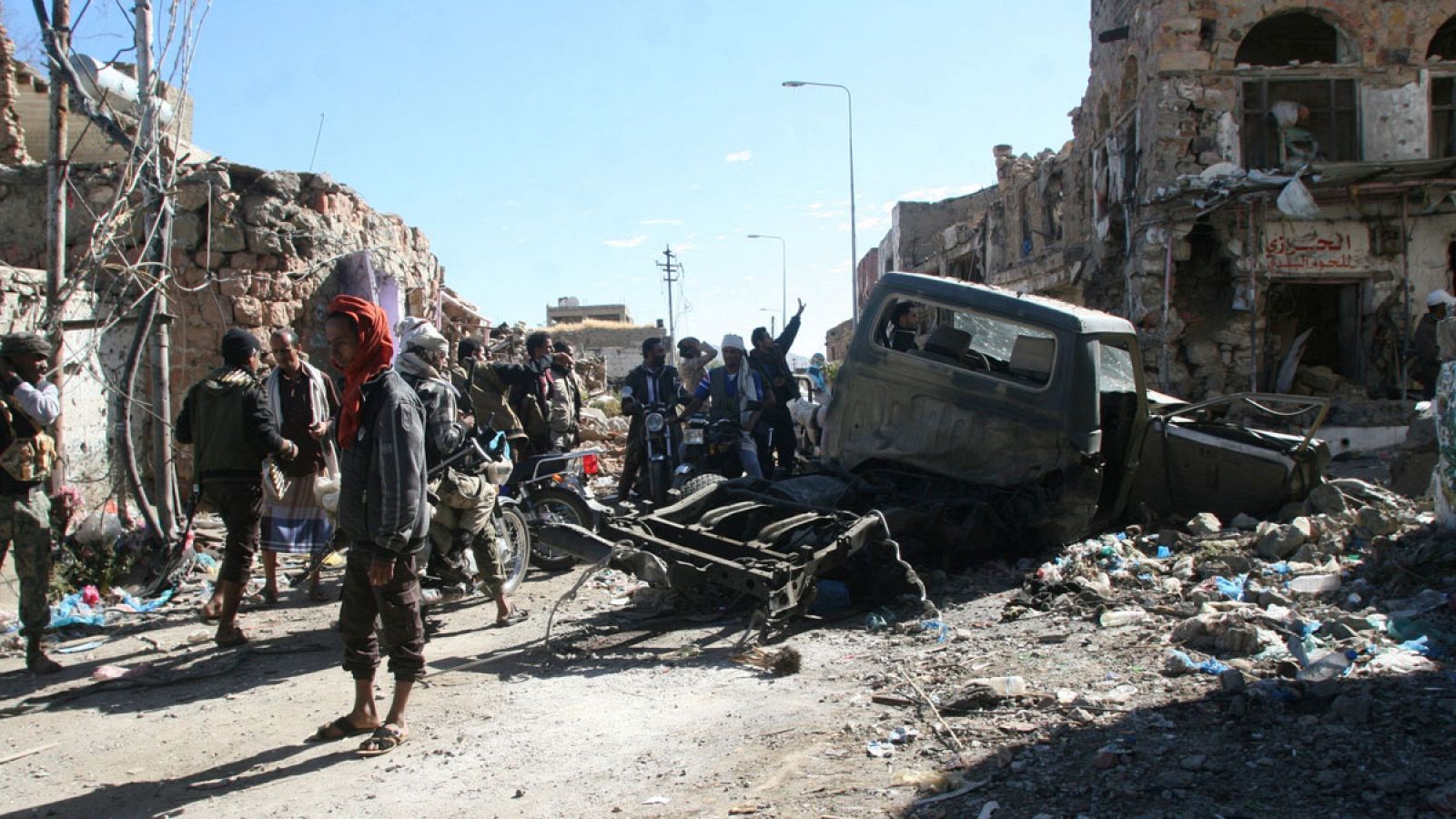 Varias personas observan en una calle de Taiz (Yemen) los destrozos de los últimos combates.