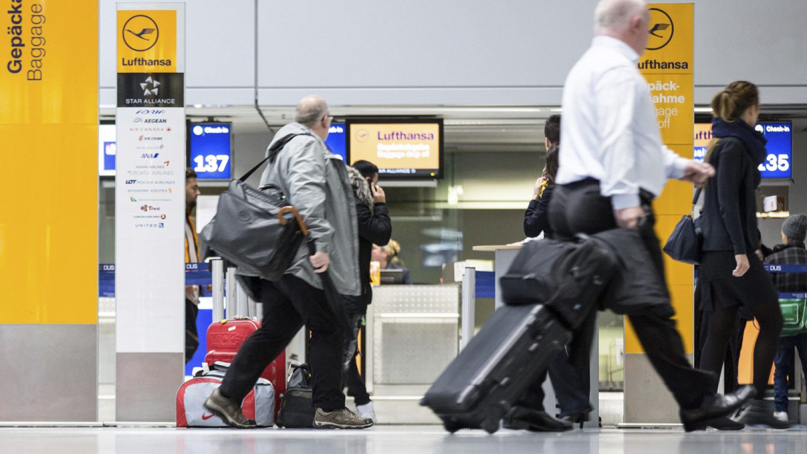 Pasajeros esperan en los mostradores de facturación de Lufthansa en el aeropuerto de Dússeldorf, en Alemania.