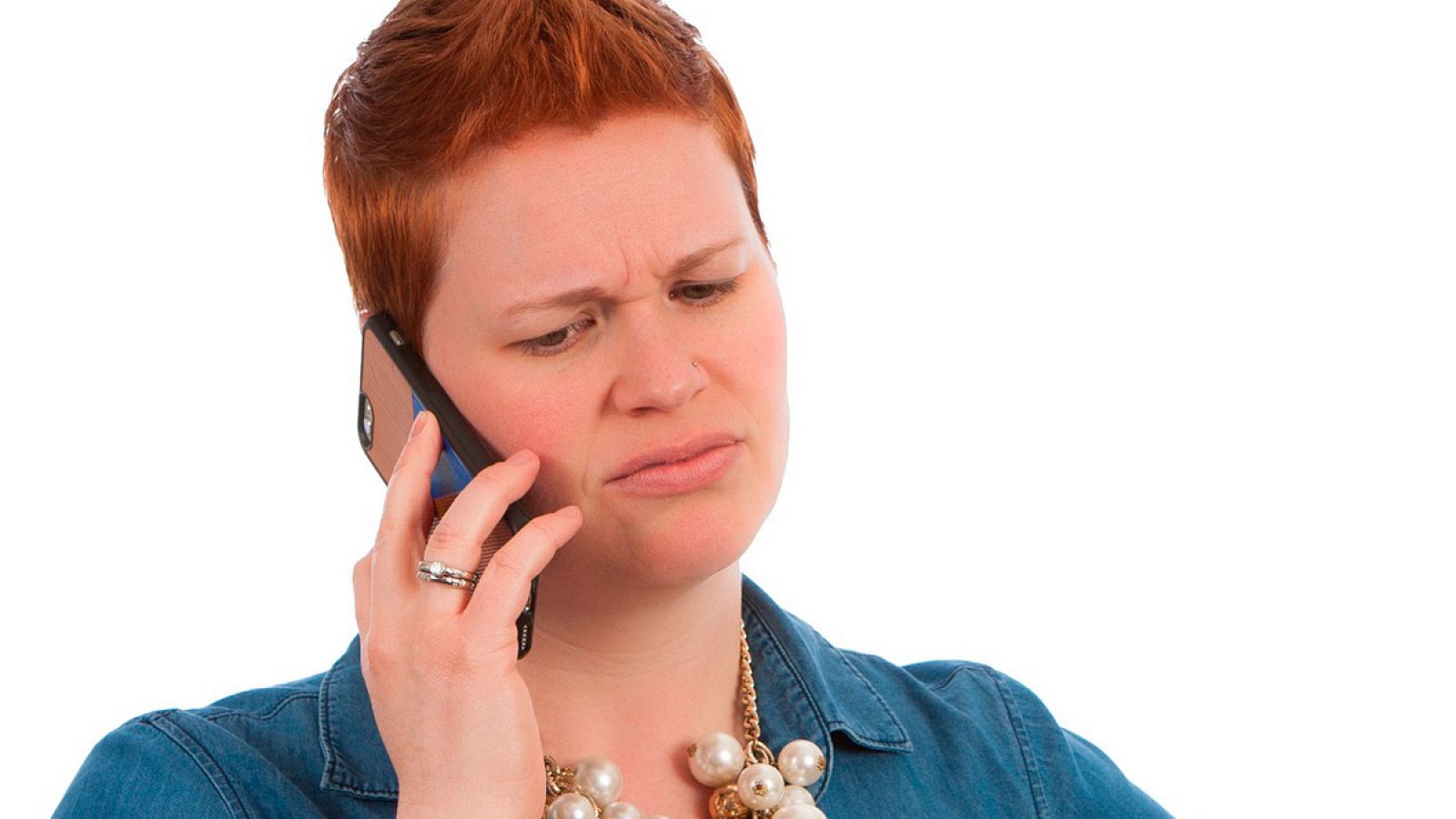 Una joven habla por su teléfono móvil con gesto de disgusto