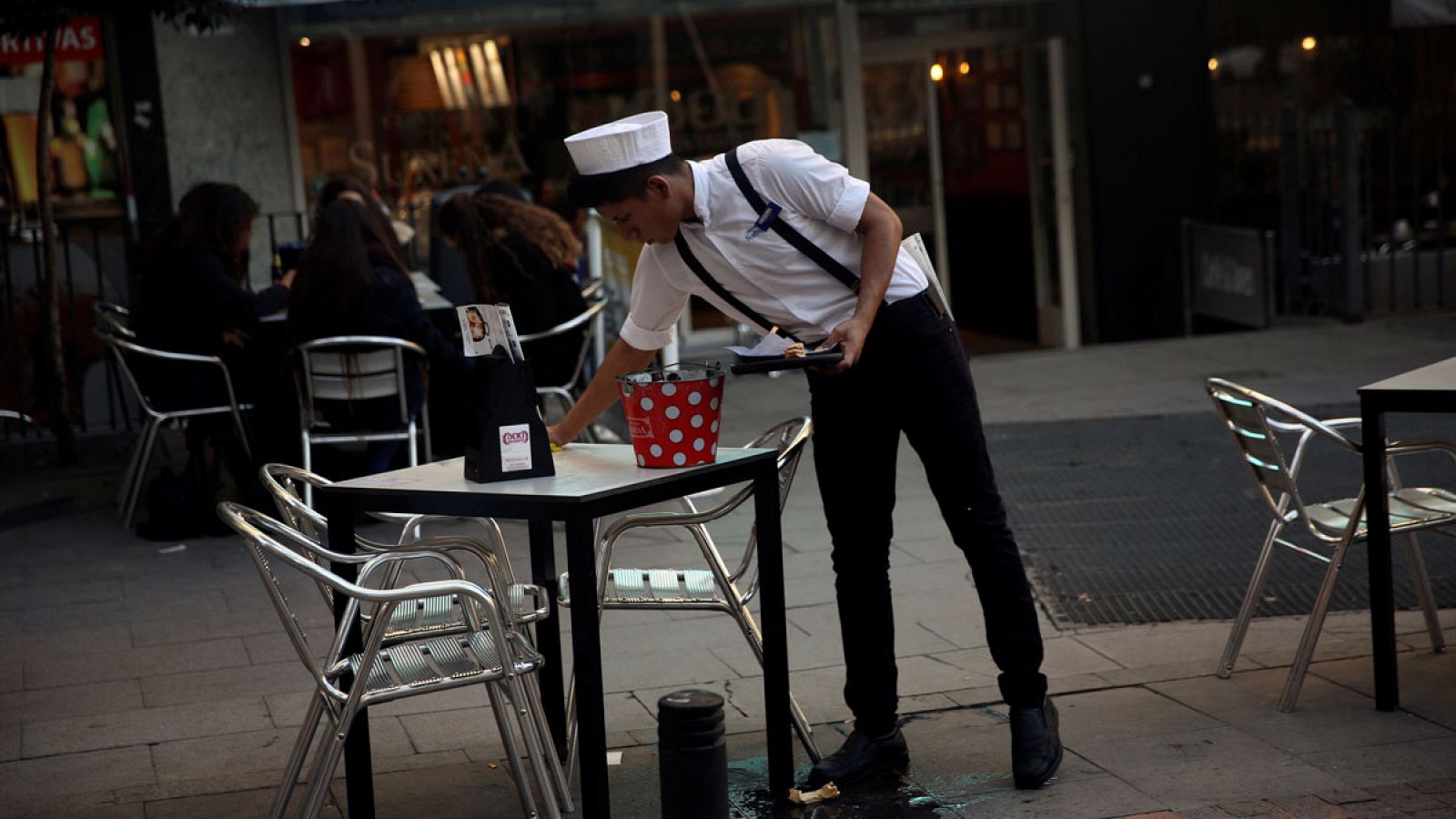 Un camarero recoge una mesa en Madrid