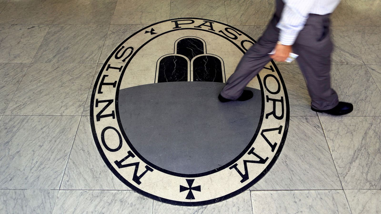 Un hombre camina sobre el logo del Monte dei Paschi di Siena en una imagen de archivo