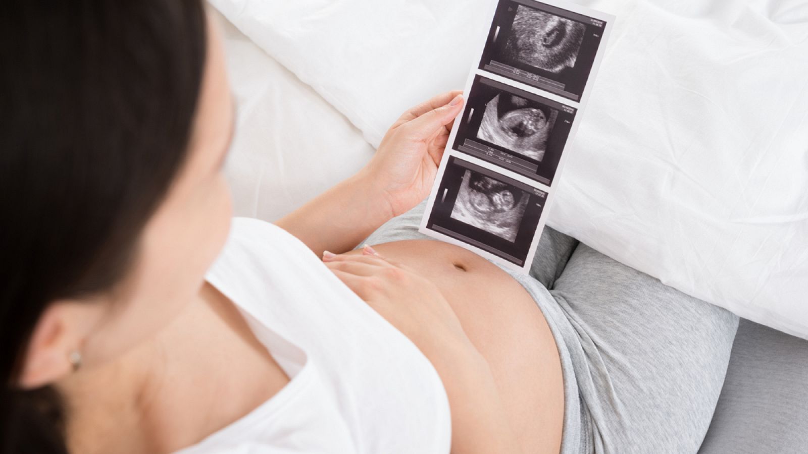 Una mujer embarazada con la ecografía de su bebé.