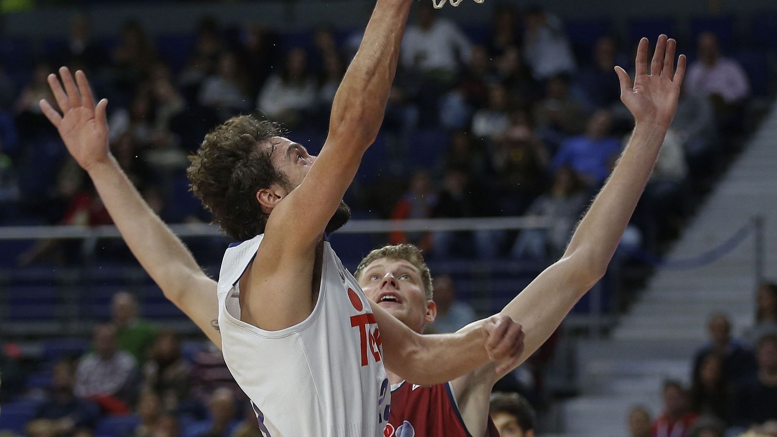 El base del Real Madrid Sergio Llull (i) intenta una canasta ante Artem Pustovyi, del Obradoiro