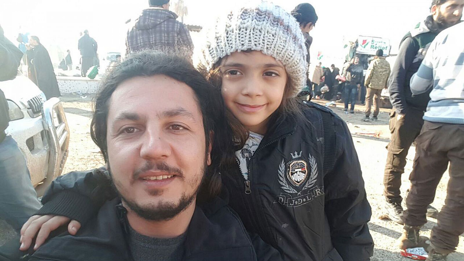 Bana Alabed posa sonriente con uno de los cooperantes que la ha sacado del este de Alepo.