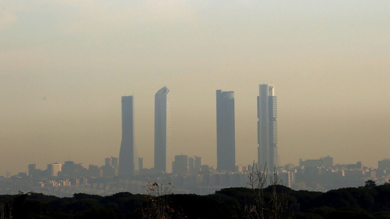 Las Cuatro Torres vistas desde Majadahonda se perfilan entre la nube de polución de Madrid.