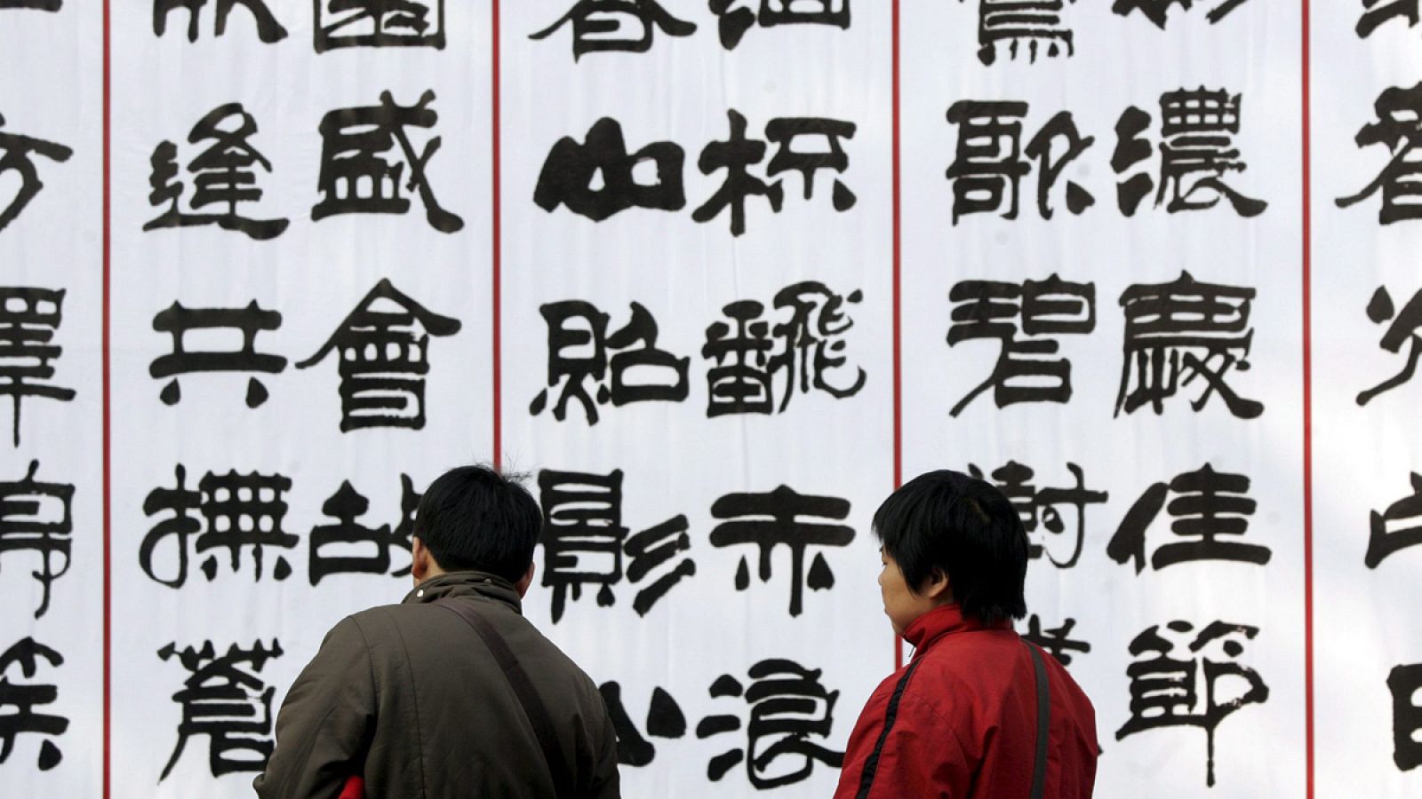 Dos personas observan unos carteles de caligrafía treadicional china
