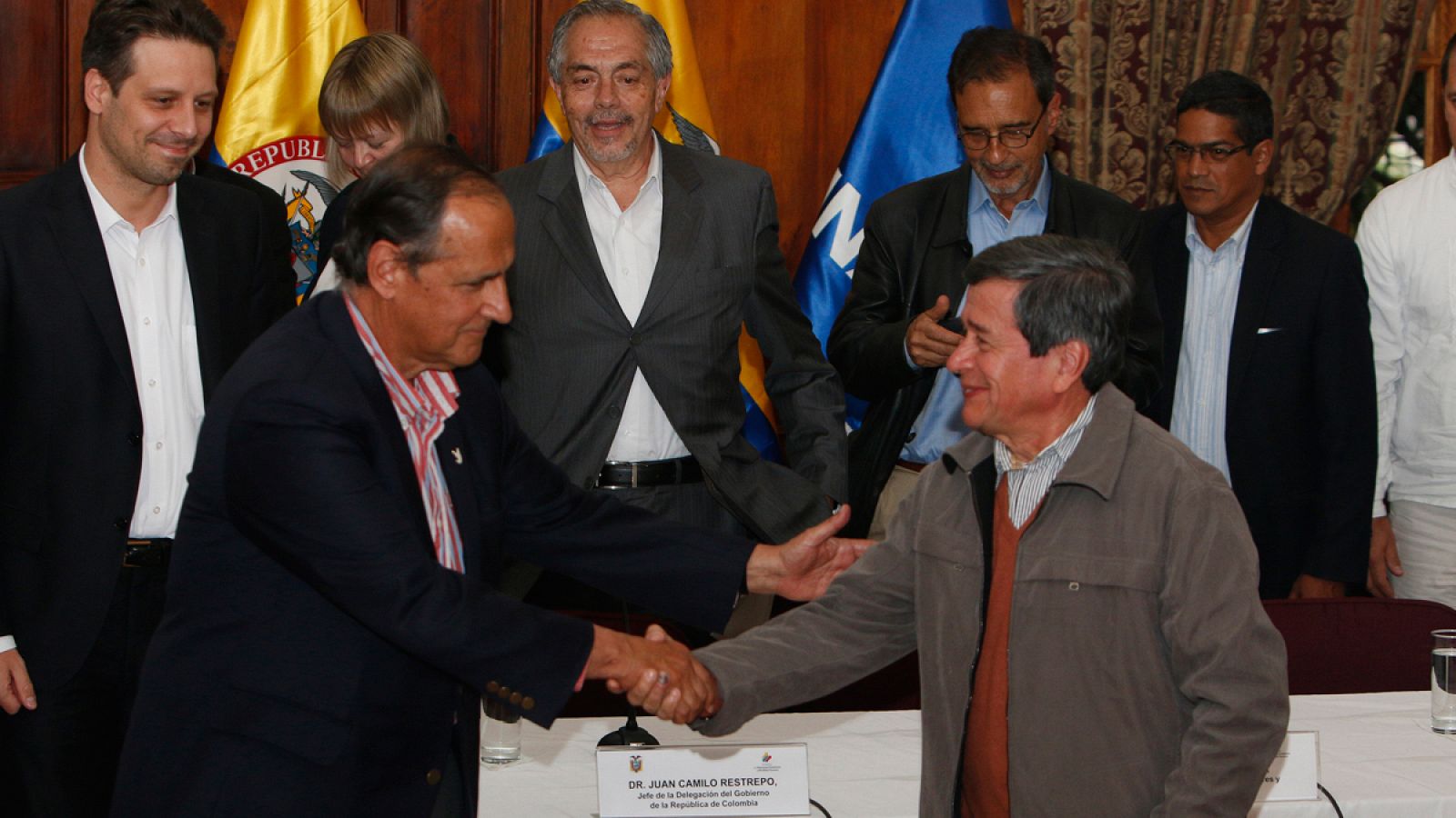 El jefe negociador de Colombia Juan Camilo Restrepo estrecha la mano con el jefe negociador del ELN Pablo Beltrán en Quito.