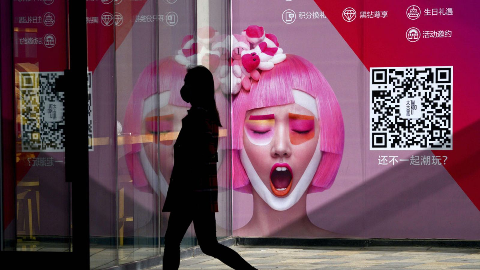 Una mujer pasa por delante de un anuncio en la entrada de una tienda de ropa en Pekín el pasado 13 de enero de 2017.