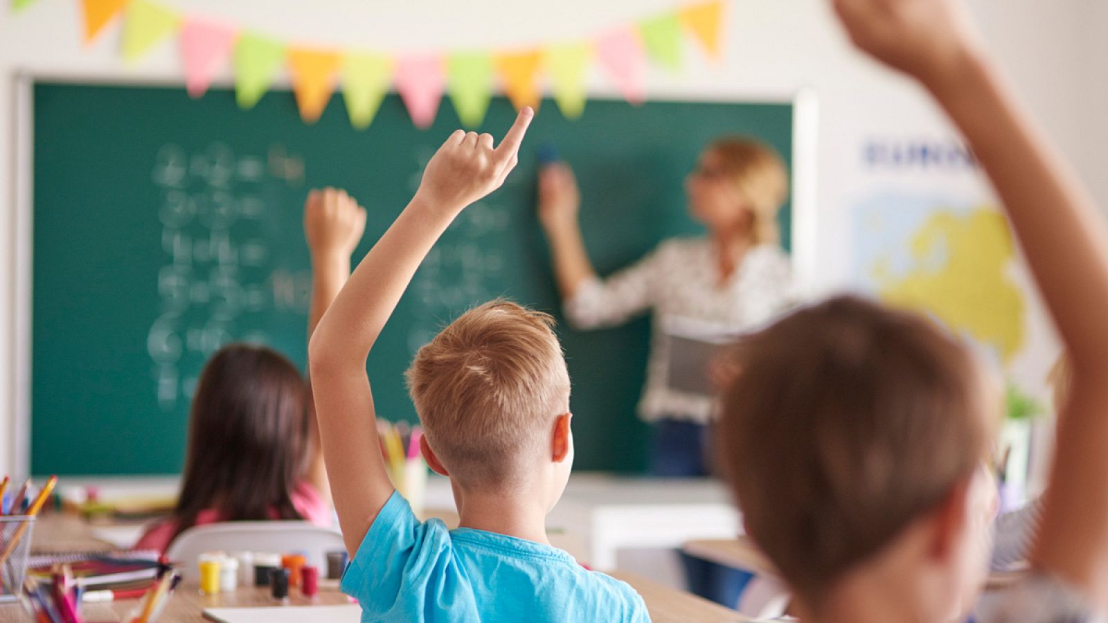 Alumnos en clase atendiendo a la profesora