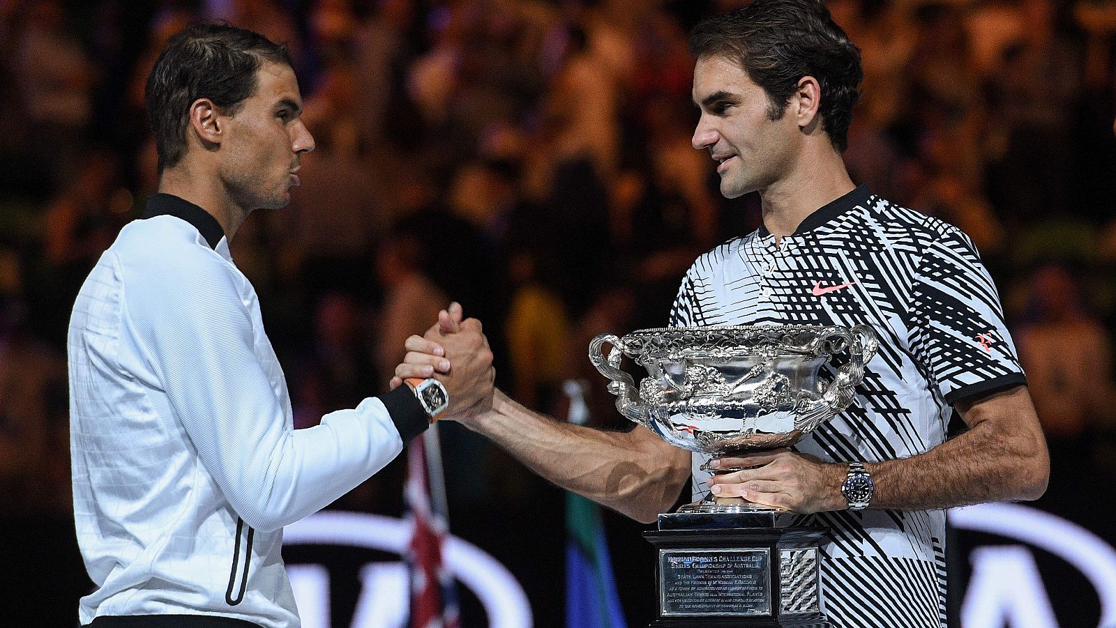 Nadal y Federer, con la copa de campeón del Open de Australia, se saludan.