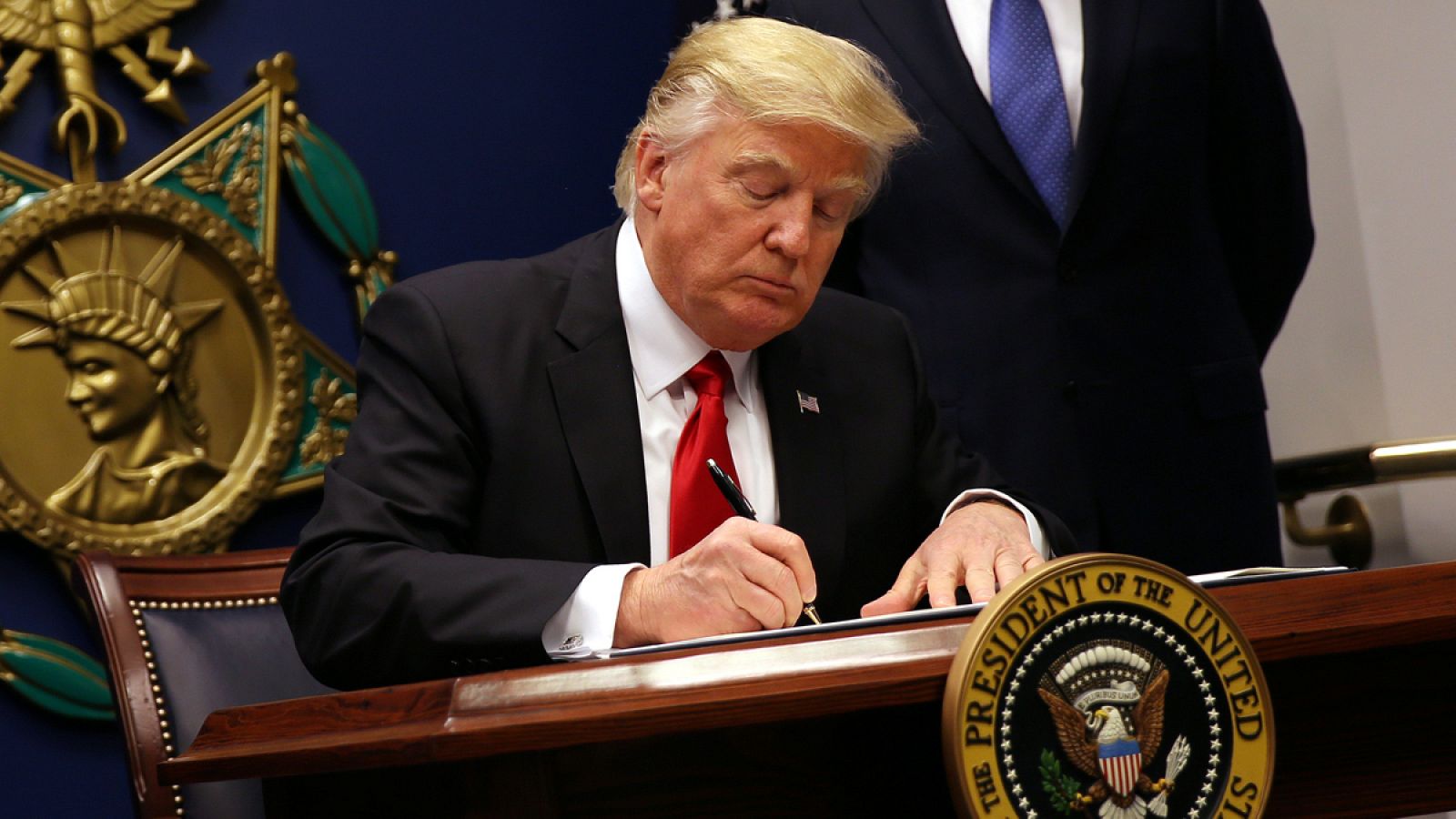 El presidente de EE.UU., Donald Trump, firma la orden ejecutiva que veta temporalmente la entrada a refugiados.