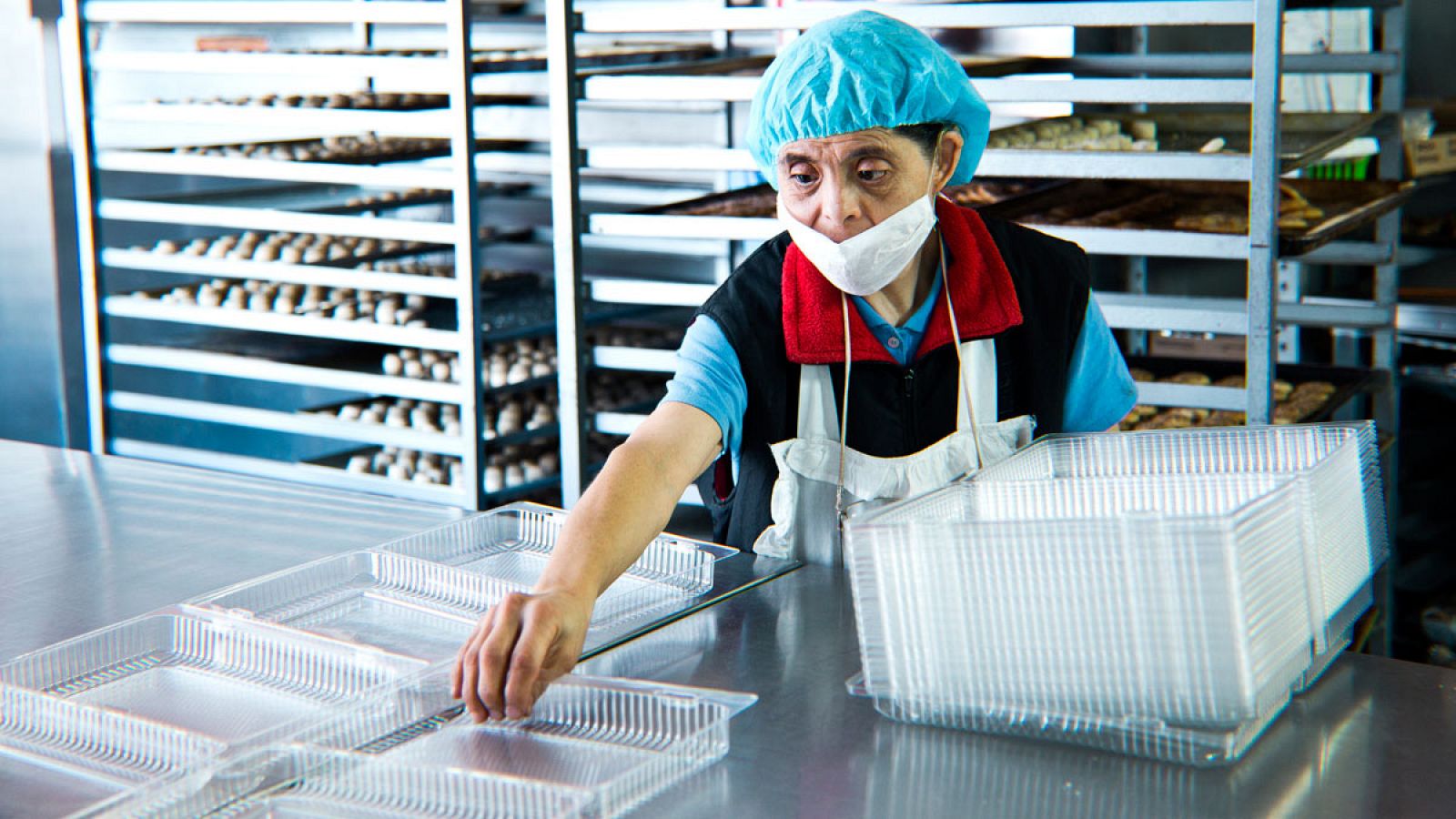 Una trabajadora con discapacidad desempeña sus funciones en una panadería.