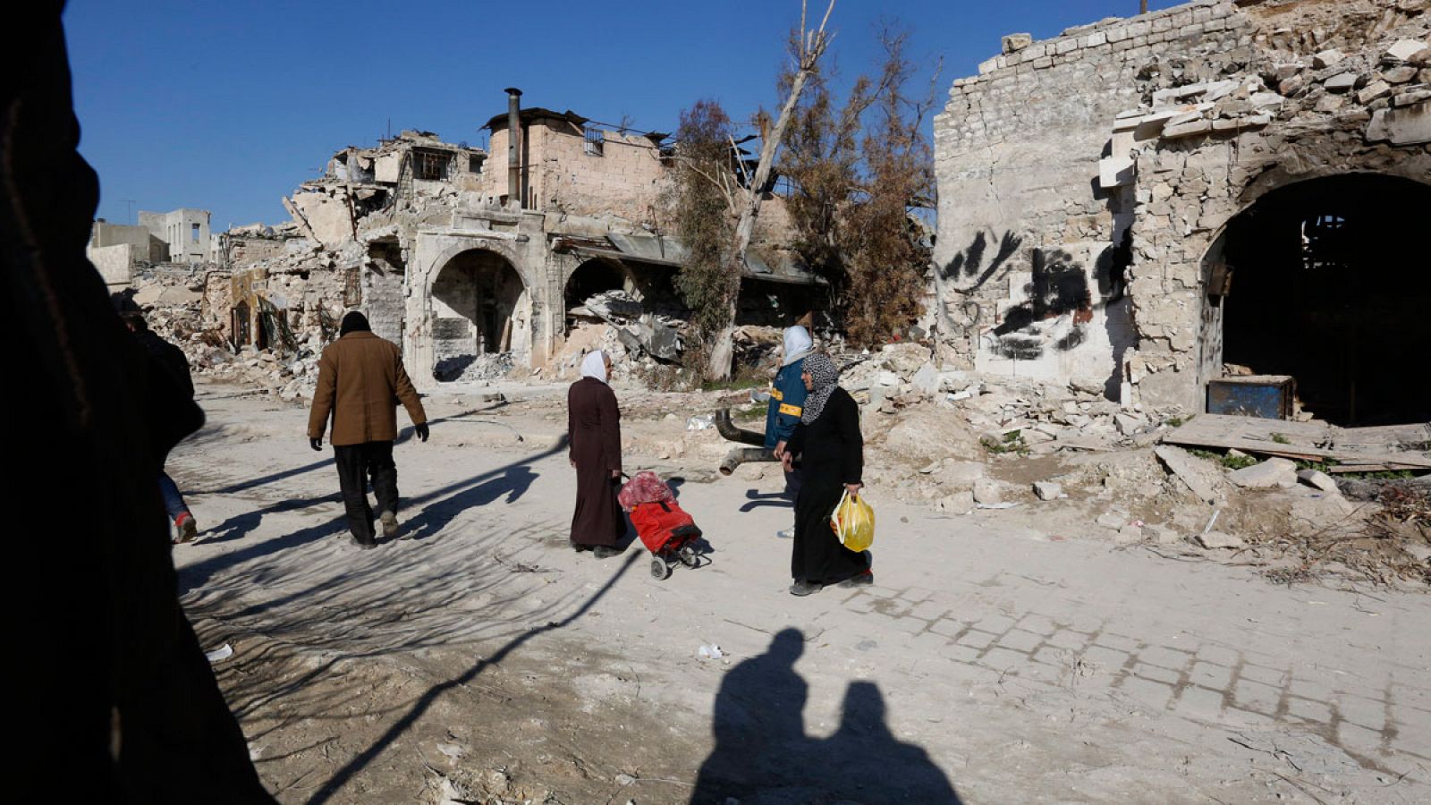 Un grupo de personas camina entre escombros en la Plaza Al-Hatab en un área de Alepo (Siria) el pasado 2 de febrero de 2017.
