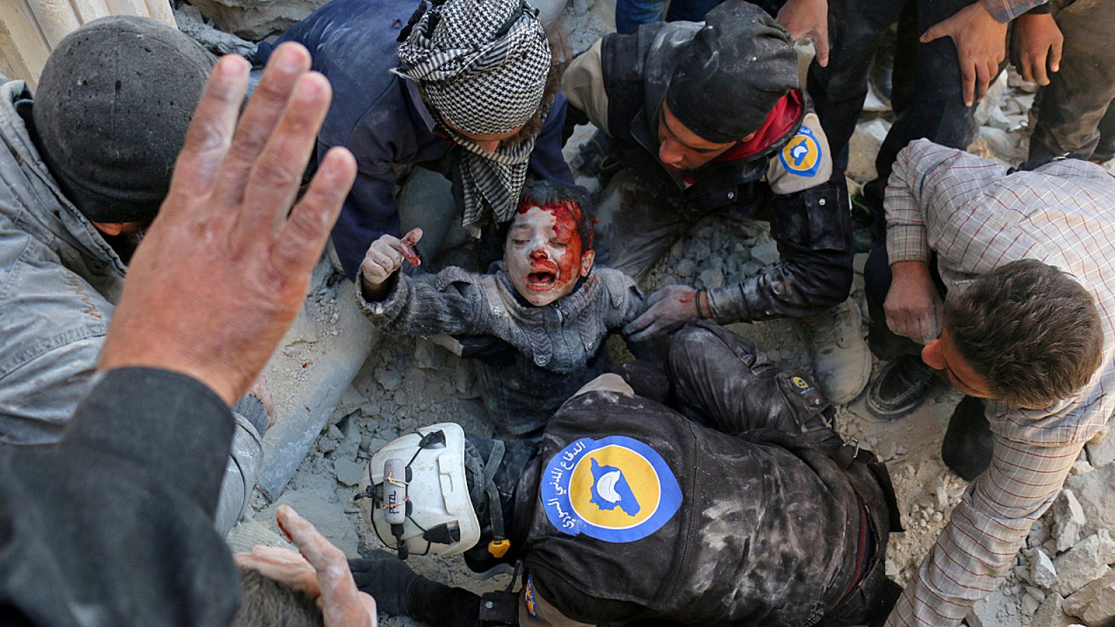 Un grupo de voluntarios sirios mientras rescata a un niño de entre los escombros tras la explosión de una bomba en Alepo el pasado 24 de noviembre.