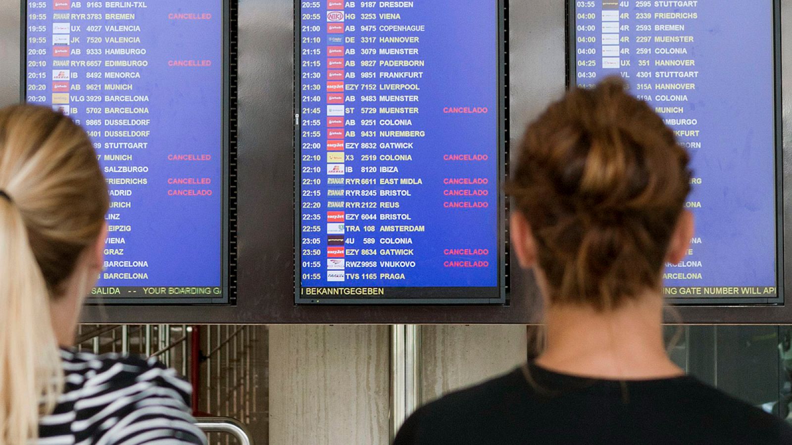 Imagen de archivo en la que varias personas observan un panel informativo del aeropuerto de Palma