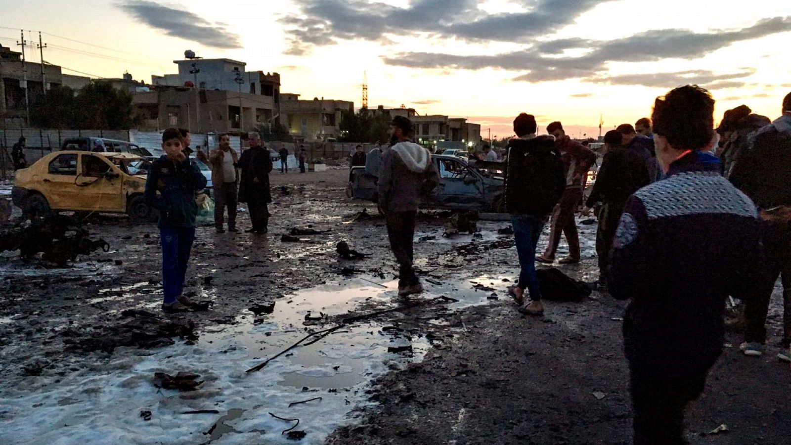 Varias personas acuden al lugar del atentado, un mercado de coches de segunda mano del sur de Bagdad