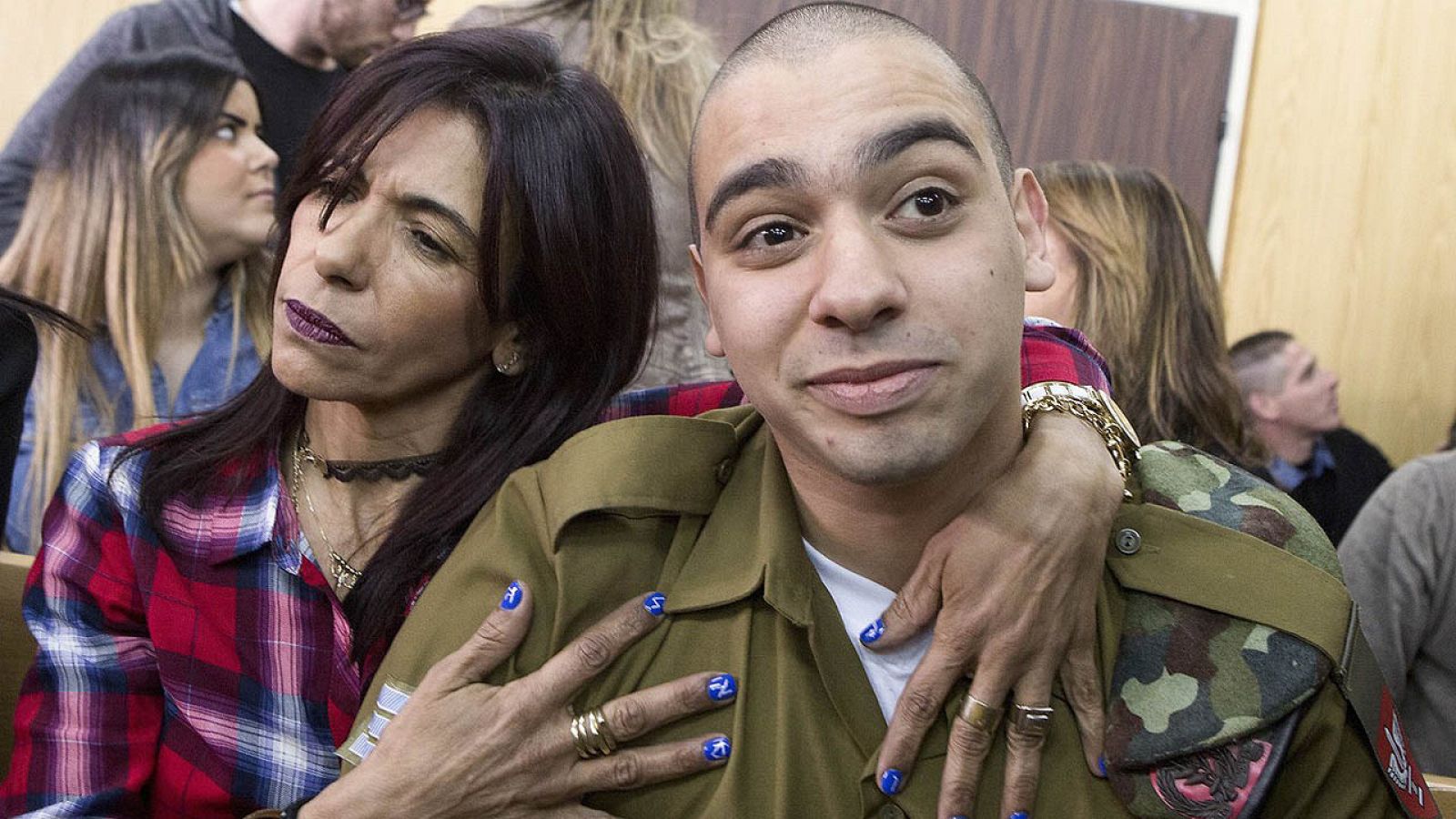 El soldado israelí Elor Azaría (d), abrazado por su madre antes de escuchar el veredicto de un Tribunal militar israelí en Tel Aviv que le condenó por asesinato