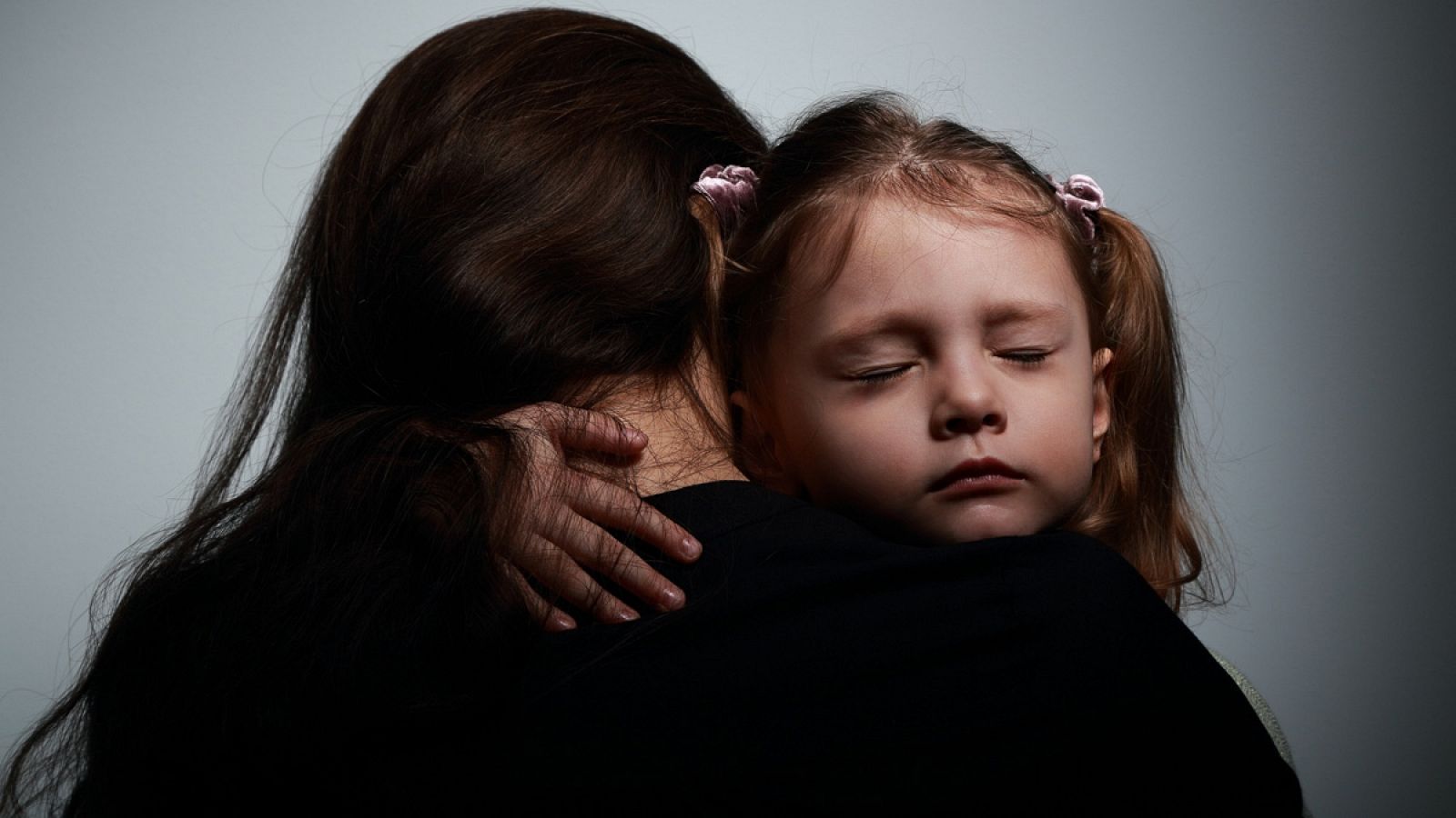 Una niña abraza a su madre, que está llorando