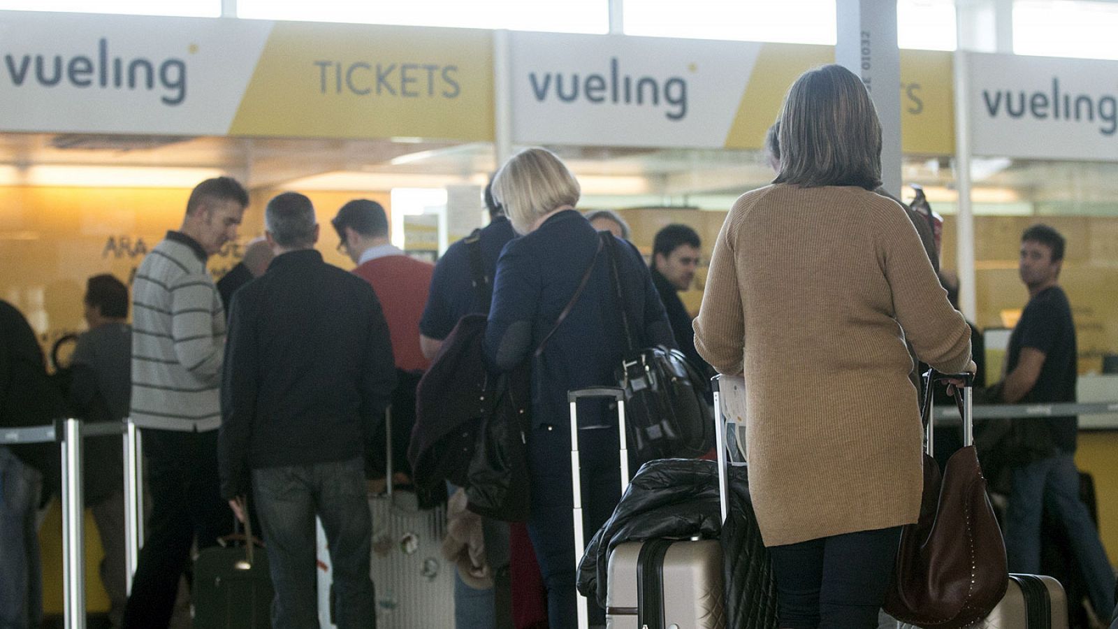 Viajeros consultan las cancelaciones de Vueling en el Prat (Barcelona)