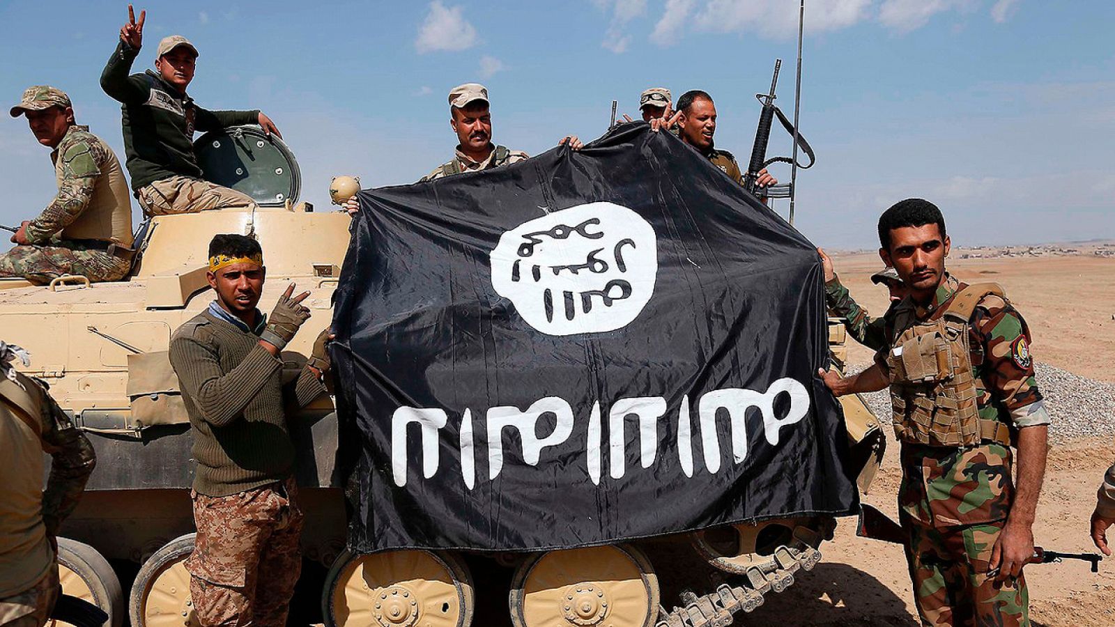Fuerzas iraquíes con una bandera arrebatada al Estado Islámico cerca de Mosul