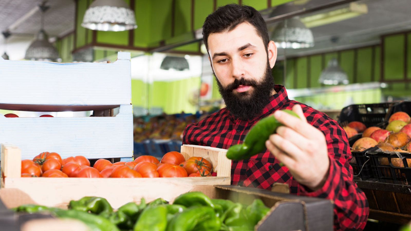 El propietario de una frutería coloca el género.