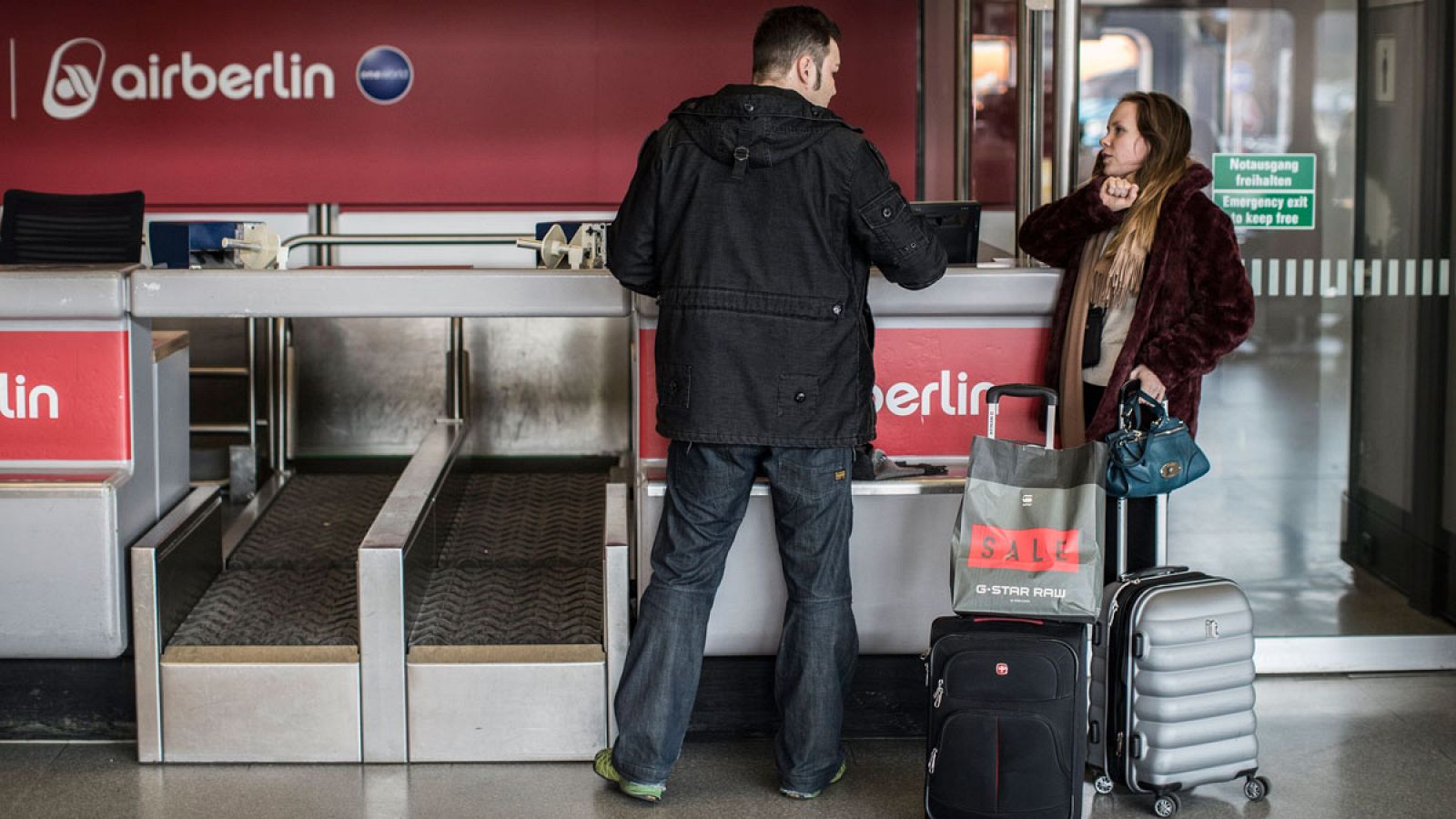 Pasajeros afectados por la huelga del personal de tierra esperan en un mostrador de facturación cerrado en el aeropuerto Tegel en Berlín (Alemania)