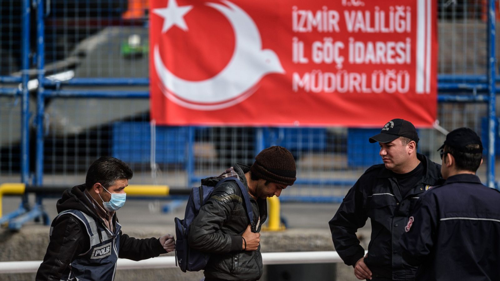 Policías turcos escoltan a un grupo de migrantes procedentes de Europa en el puerto de Dikili (foto archivo)