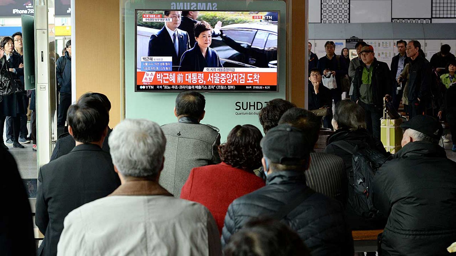 Surcoreanos pendientes de la declaración de la expresidenta Park en una estación de tren en Seúl.