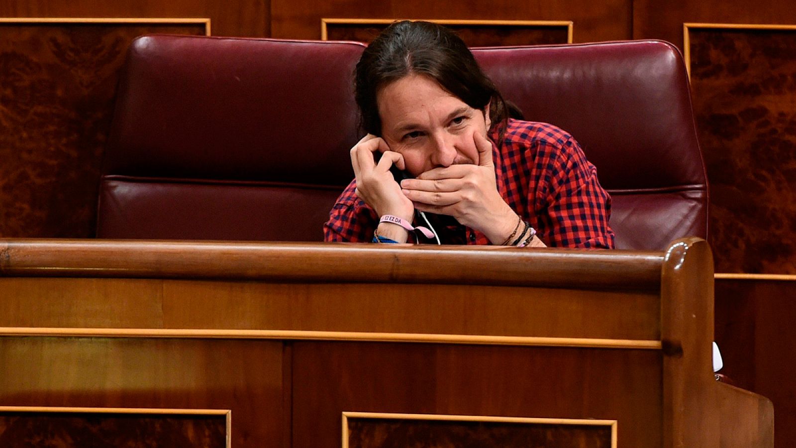 El líder de Podemos, Pablo Iglesias, habla por teléfono durante el pleno del Congreso de los Diputados