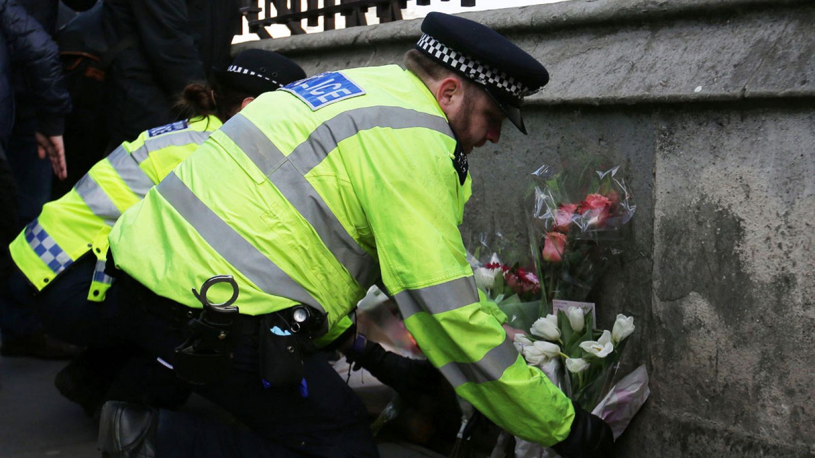 Un oficial de policía deposita flores en el puente de Westminster en honor de las víctimas del atentado de Londres del miércoles 22 de marzo de 2017.