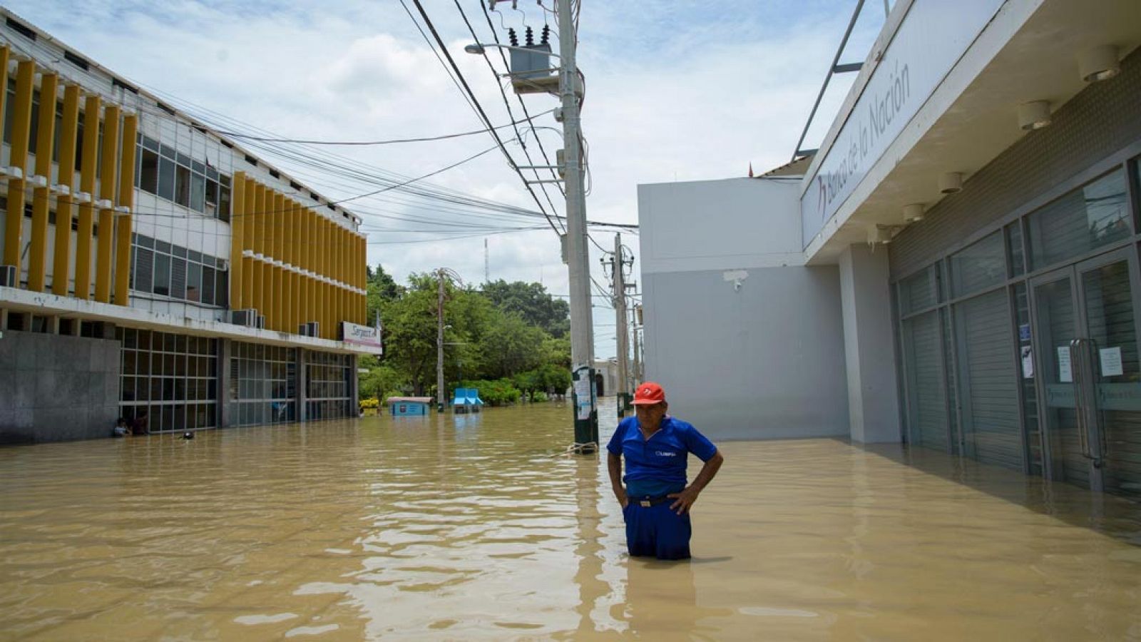 Un hombre permanece en la calle tras el desbordamiento del río Piura en Perú