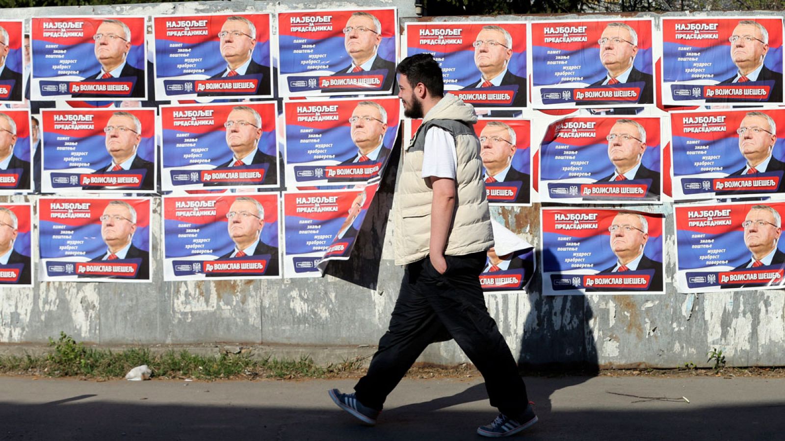 Un hombre pasa junto a varios carteles electorales en Belgrado, Serbia