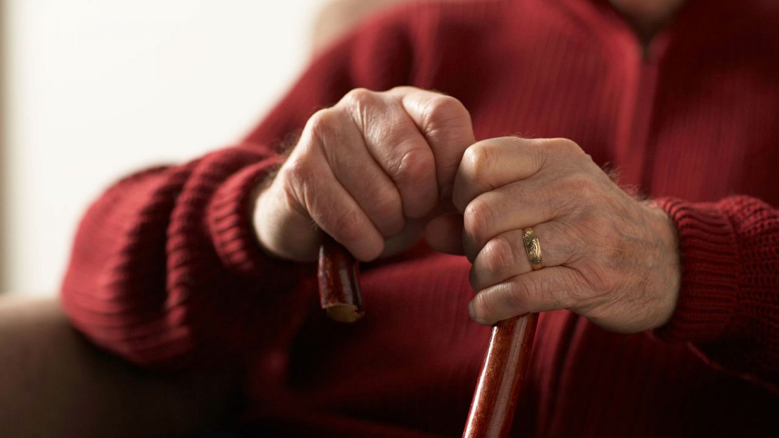 Las manos de una anciana con un bastón