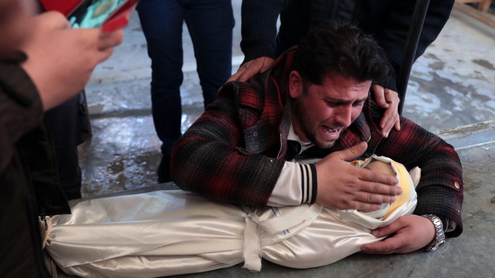 El padre de la pequeña Amira, muerta en un ataque de la aviación siria sobre la loclidad de Duma, abraza a su hija