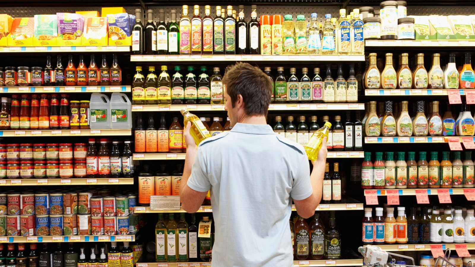 Un comprador compara dos productos en un supermercado