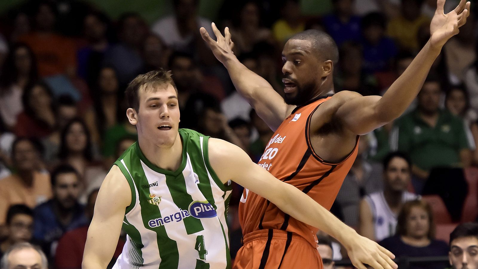El ala-pívot estadounidense del Valencia Basket, Will Thomas (d), defiende al base serbio del Real Betis Nikola Radicevic