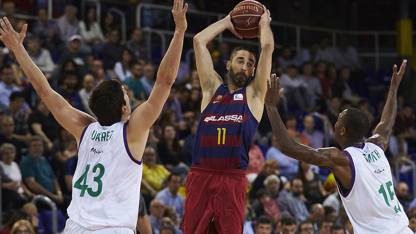 Juan Carlos Navarro (c) tira a canasta ante Carlos Suárez (i) y Jamar Smith (d) durante el partido