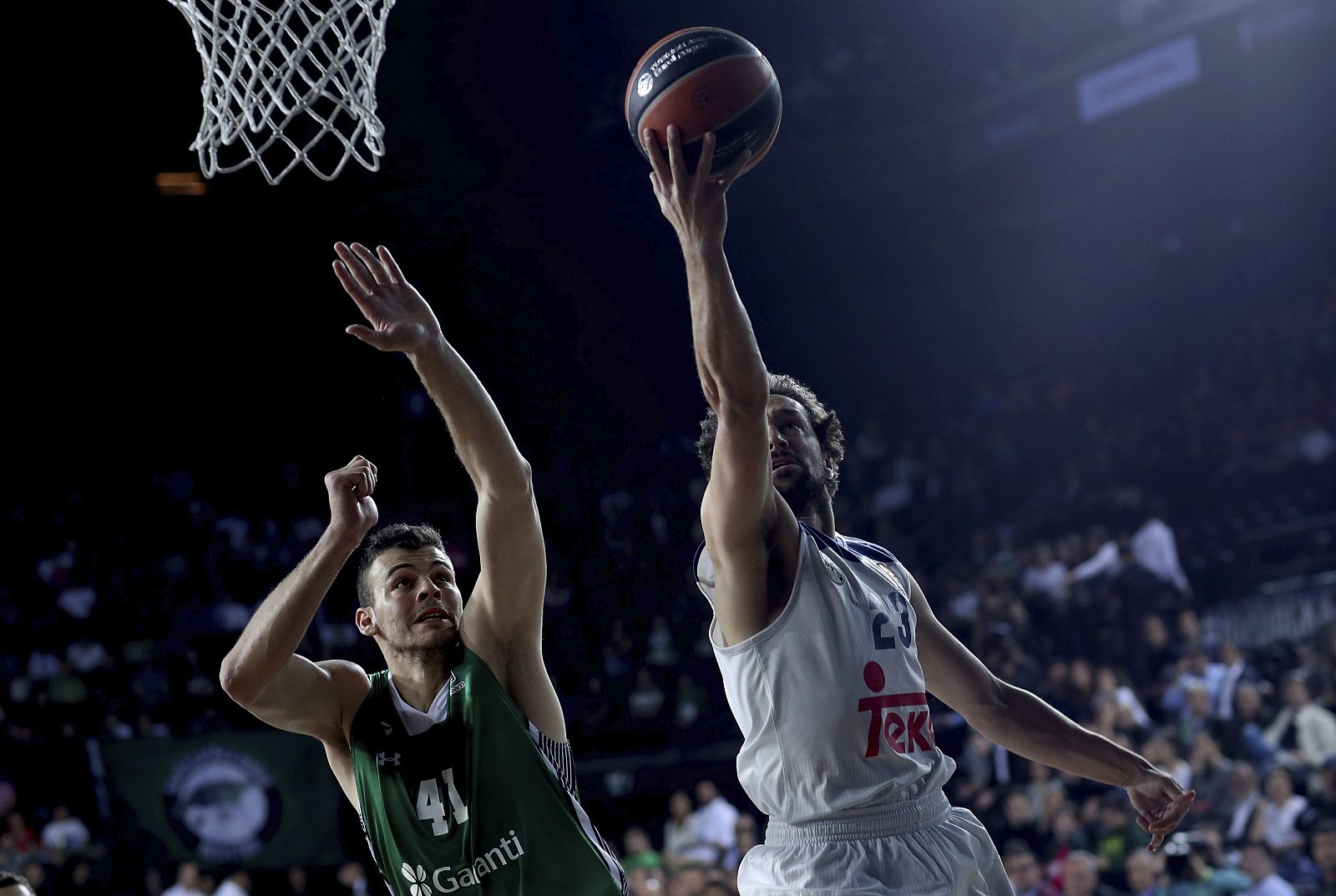 Sergio Llull (d) lanza el balón frente al pívot croata del Darussafaka Dogus, Ante Zizic (i).