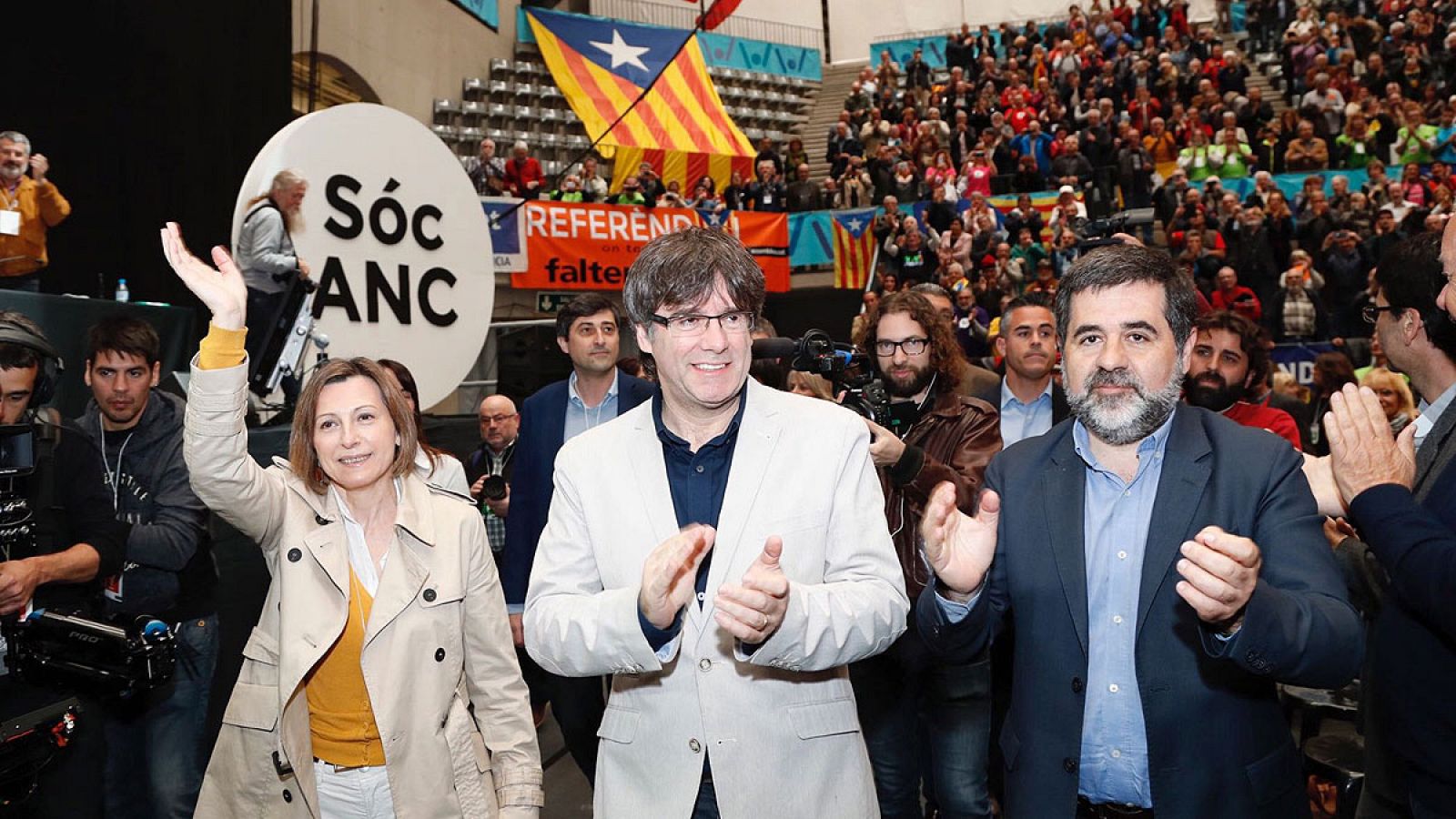 Carles Puigdemont (c), el presidente de la entidad soberanista, Jordi Sánchez (d), y la presidenta del Parlament, Carme Forcadell (i), en la Asamblea de la ANC