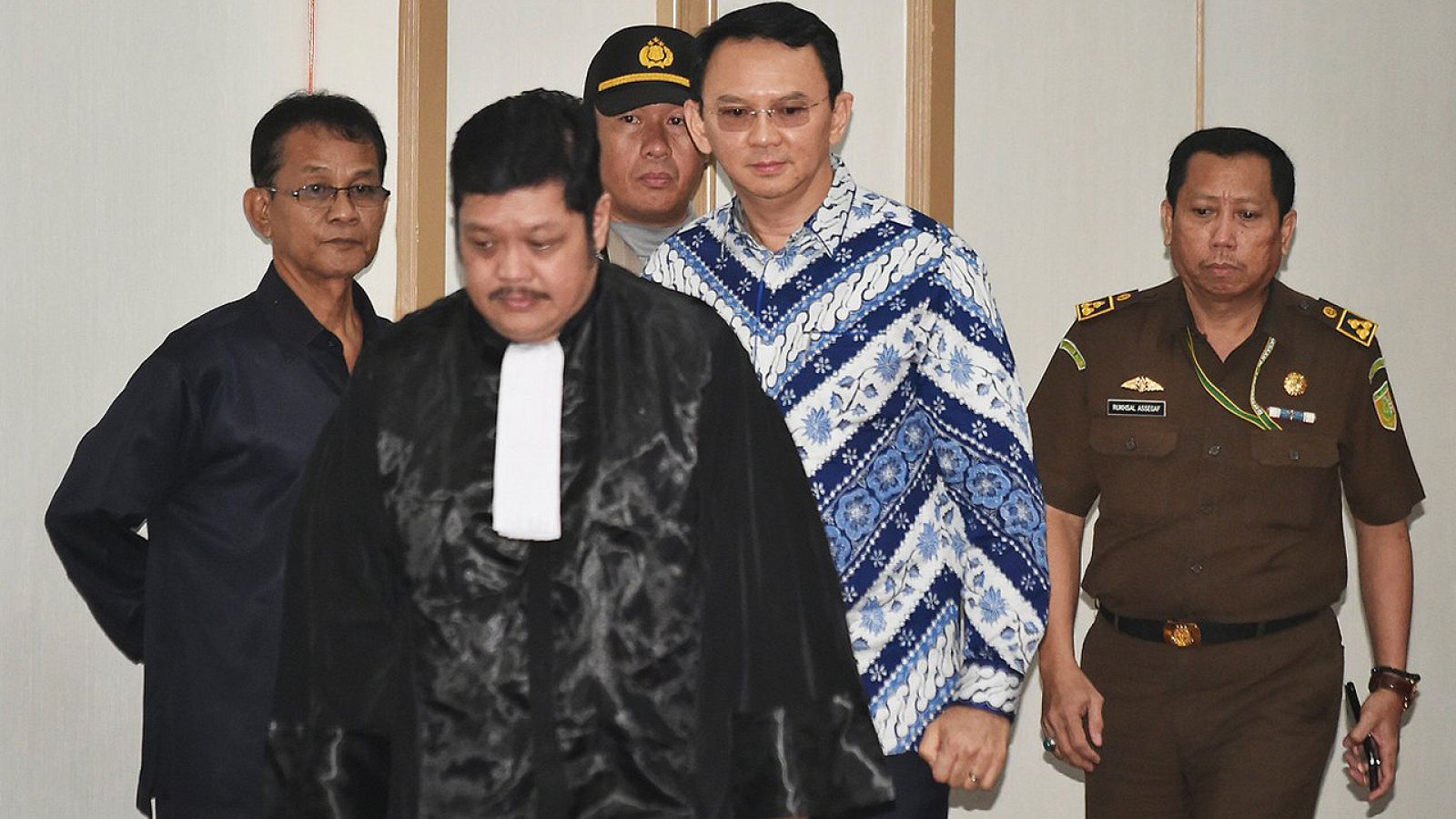 El actual gobernador de Yakarta, Basuki Tjahaja Purnama (centro, con camisa azul, popularmente conocido como Ahok, entra en un tribunal durante su juicio