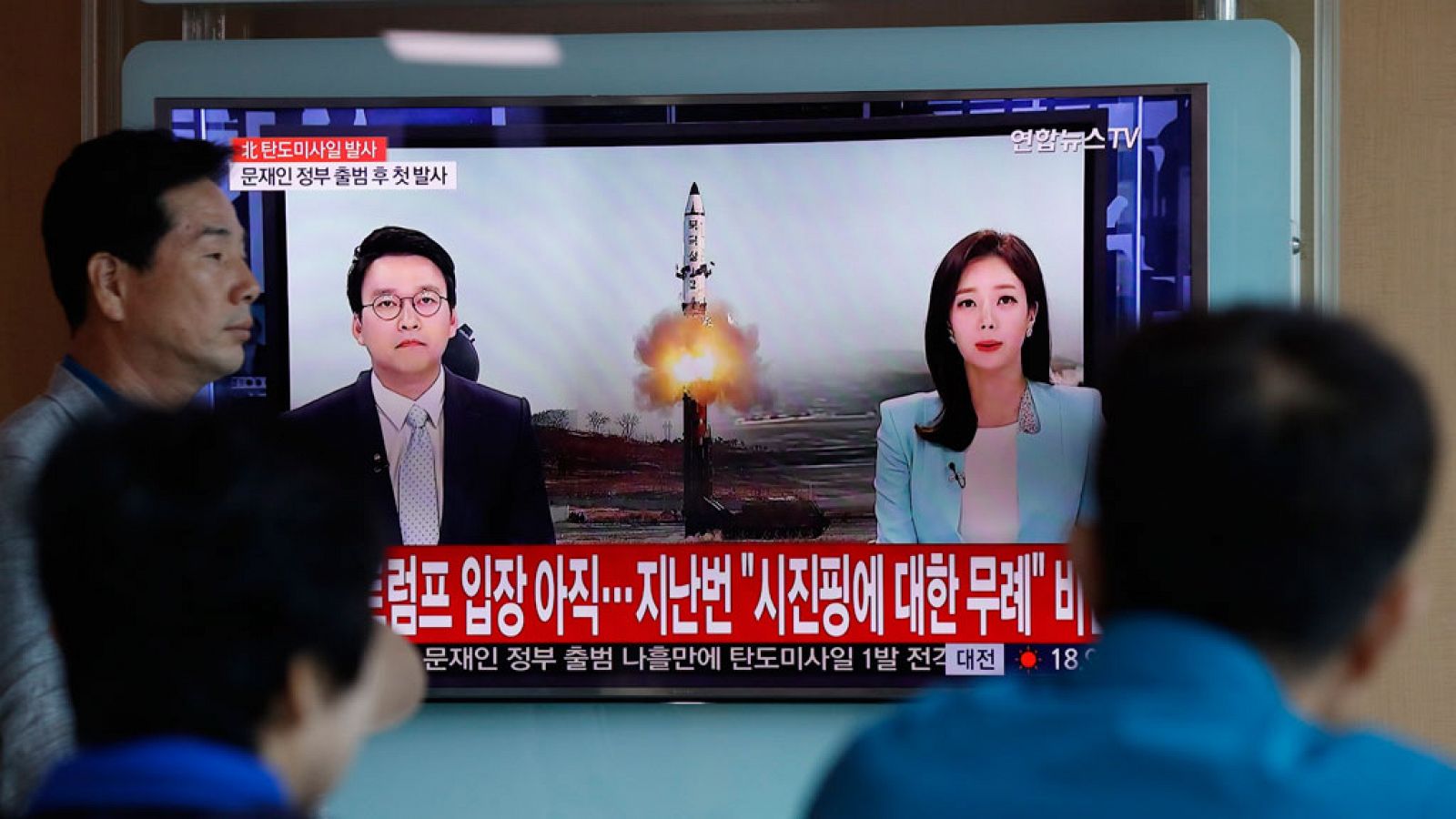 Surcoreanos viendo en la televisión la información sobre el último desafío norcoreano.