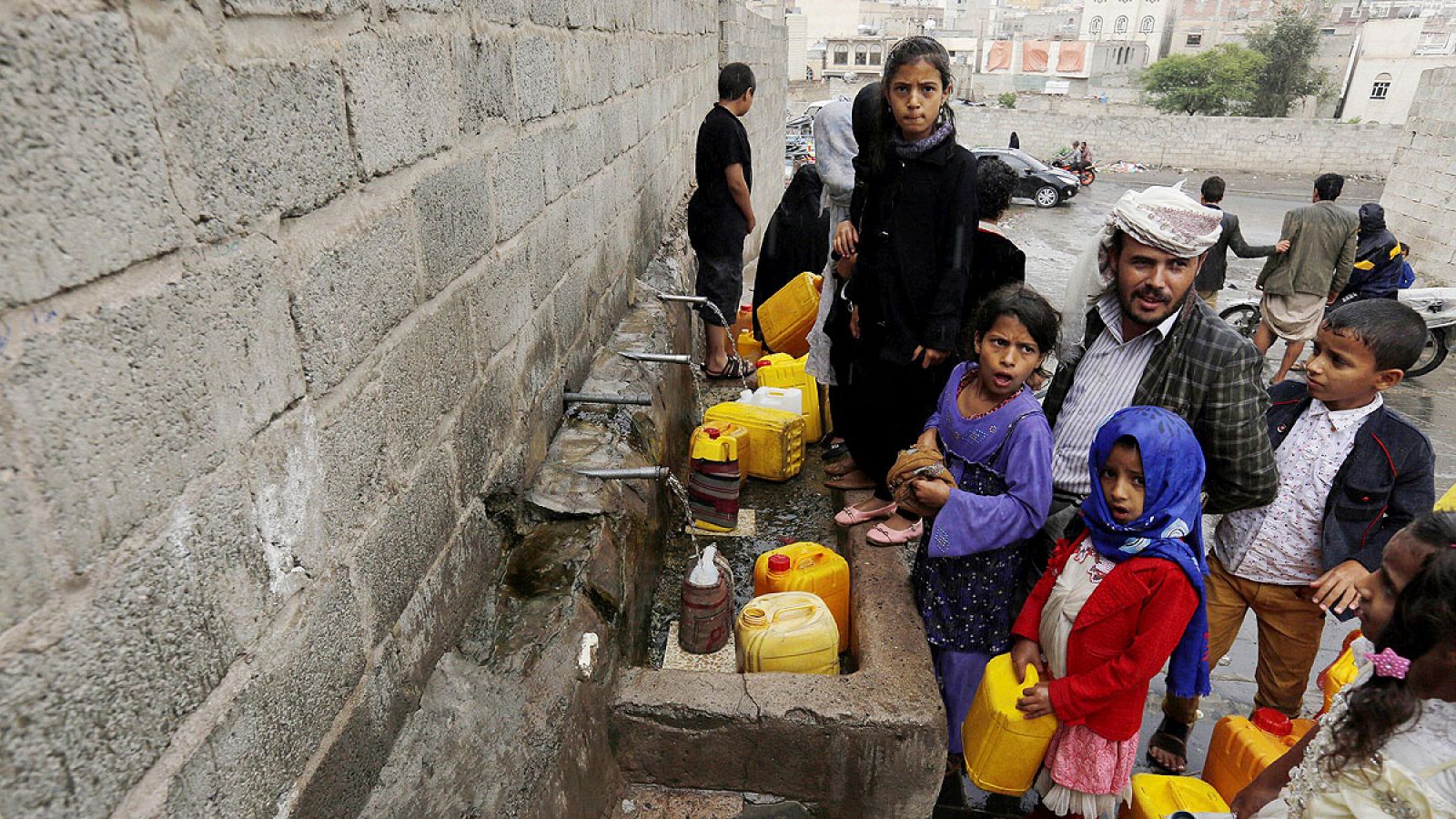 Varias personas recogen agua de una fuente en Saná, Yemen